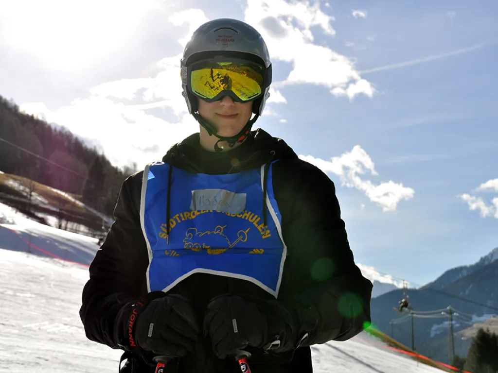 Jugendlicher mit Helm und Skibrille im Gegenlicht.